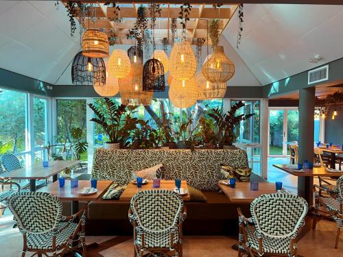 巴瑟尔顿Broadwater Resort WA Tourism Awards 2022 Gold Winner的用餐室配有桌椅和吊灯。