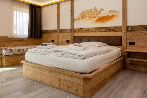 索拉加Wellness Hotel Dolomia的一间卧室配有一张木架大床