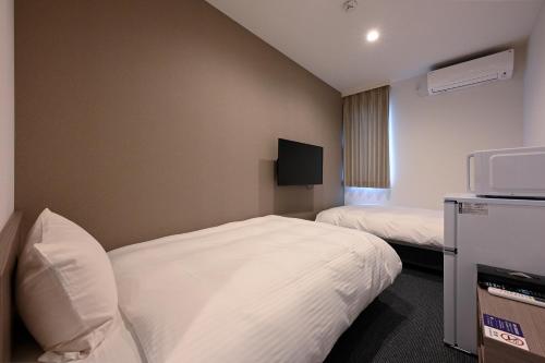 鹿沼HOTEL R9 The Yard Kanuma Sakae的一间酒店客房,设有两张床和电视