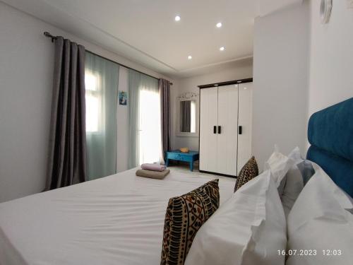 莫纳斯提尔Residence Debbabi的卧室配有一张带两把椅子的白色大床