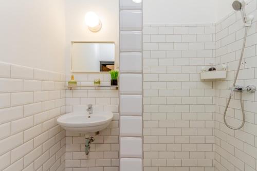 布达佩斯Central Studio @ Jászai Mari Square的白色瓷砖浴室设有水槽和淋浴