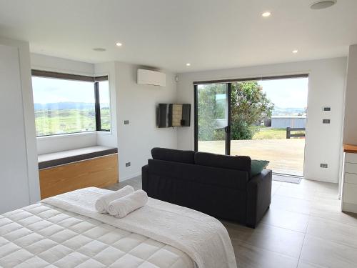 芒阿法埃Vineyard Vacation的一间卧室配有一张床、一张沙发和窗户。