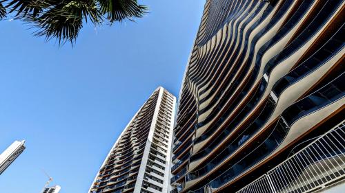 贝尼多姆SUNSET WAVES sun & beach apartments的一座高大的建筑,背后是蓝天