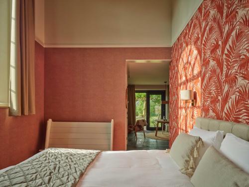 ReitsumKerkhotel Bij De Pastorie的一间卧室设有一张床和红色的墙壁