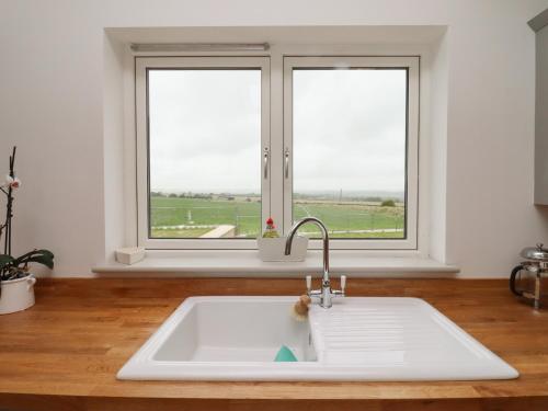 奇平诺顿Cotswold View的带2扇窗户的厨房内的白色水槽