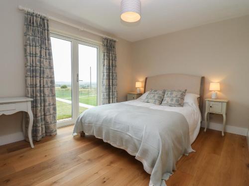 奇平诺顿Cotswold View的一间卧室设有一张床和一个大窗户