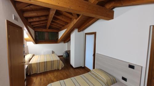 FaedisWine Resort的一间卧室设有两张床和木制天花板