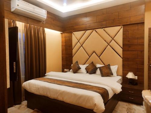 TezpurHotel Friends Palace的一间卧室设有一张带木墙的大床