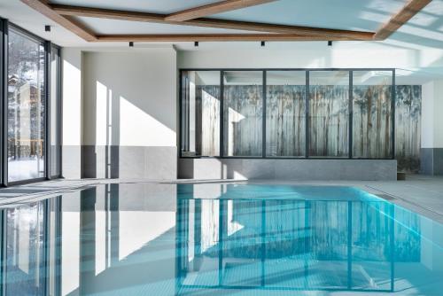 大博尔南Les Chalets de Joy的一个带玻璃墙和天花板的游泳池