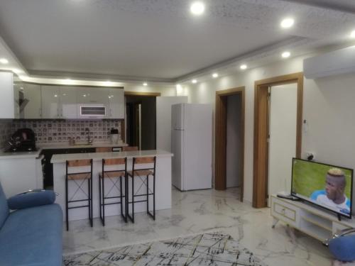 代姆雷Deniz Apart的客厅设有厨房和电视。