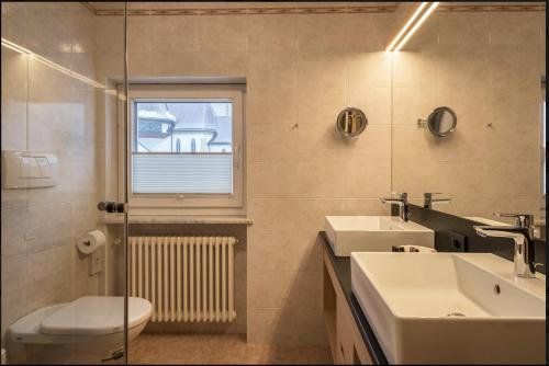 塞尔瓦迪加尔代纳山谷ARTEFUGIUM panoramico的一间带水槽和卫生间的浴室以及窗户。