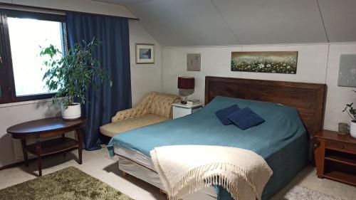 海门林纳Talo uima-altaalla的卧室配有1张床、1张桌子和1把椅子