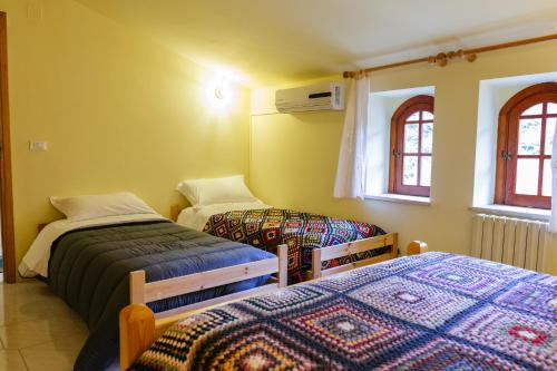 波利齐杰内罗萨Terrematte turismo e natura的一间卧室设有两张床和两个窗户。