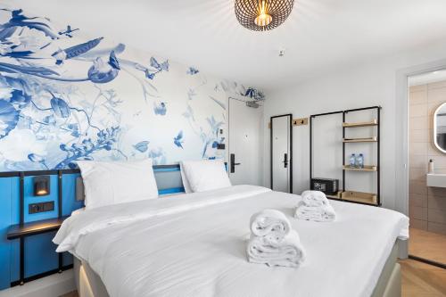 阿姆斯特丹Dutch Design Hotel Vondelpark的一间卧室配有带毛巾的床