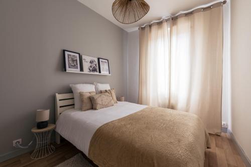 科涅克Coquette maison & extérieur的一间卧室设有一张大床和一个窗户。