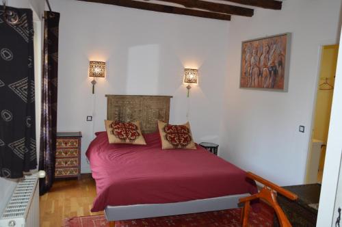 希奥拉肯·佩里戈尔Les Deux Tours的一间卧室配有一张红色大床和两盏灯