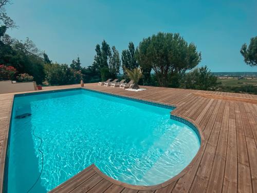 蒙巴兹雅克Villa Monbazillac, vue exceptionnelle, piscine, jacuzzi 10-16 pax的一个带木制甲板和游泳池的游泳池