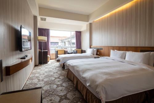 Touwu水漾月明度假文旅的酒店客房设有两张床和电视。