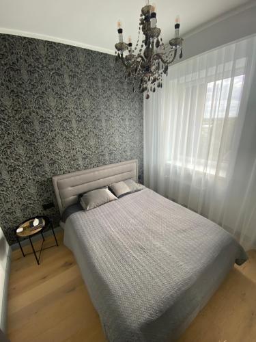 图库姆斯The SiXth的一间卧室配有一张床和一个吊灯