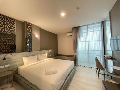 Ban Lan Dok Maiวัน บัดเจท เชียงราย เชียงแสน One Budget Hotel Chiangrai Chiangsaen的一间卧室配有一张床、一张书桌和一个窗户。