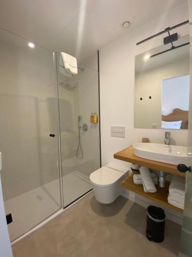 休达德亚Hotel Maïa的带淋浴、卫生间和盥洗盆的浴室