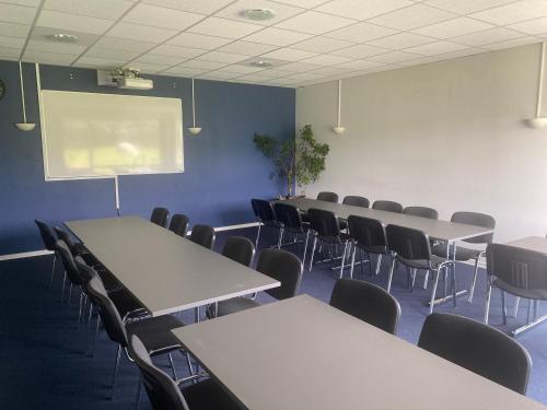 JelsDanhostel Thorhallen Jels的一间会议室,配有桌椅和投影屏幕