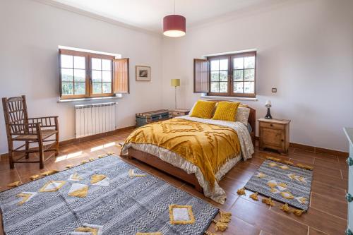 雷镇Quinta da Palhota的一间卧室配有一张床、一把椅子和窗户。
