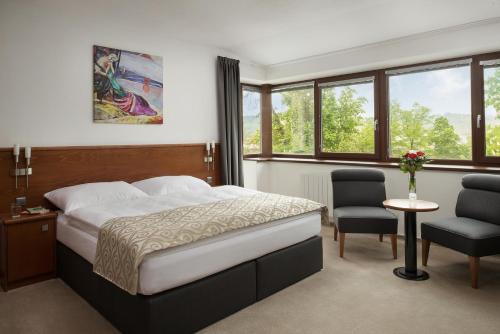 布尔诺诚信旅馆的卧室配有床、椅子和窗户。
