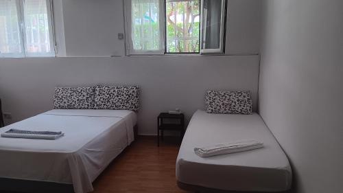 马德里El Colmenar Habitaciones的带两张床和两个窗户的房间
