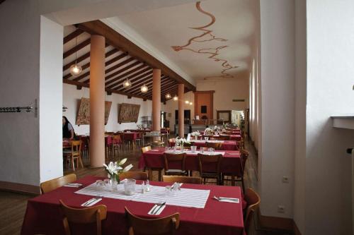 Kall施泰因费尔德修道院酒店的餐厅的一排桌子,有红色桌布