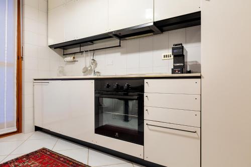 都灵i cedri的厨房配有黑烤箱和白色橱柜。