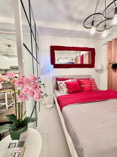 卡加盐德奥罗Aesthetic One Bedroom Beside SM w Pool, Wifi and Netflix的一间卧室配有一张带红色枕头的床和一张桌子
