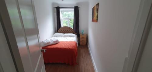 罗姆福特Lovely 3 Bedrooms Flat Near Romford Station With Free Parking的一间小卧室,配有床和窗户