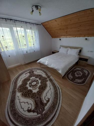 默古拉Dor de munte的卧室配有一张床,地板上铺有2个地毯。