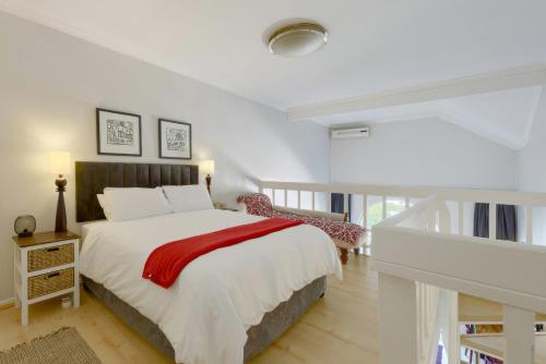开普敦Loft Apartment off Kloof with Table Mountain views的一间卧室配有一张床铺,床上铺有红色毯子