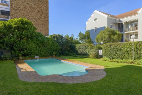 开普敦Loft Apartment off Kloof with Table Mountain views的一座游泳池,位于一座建筑旁的院子内