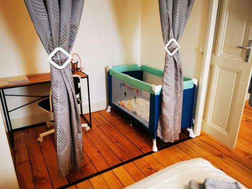 日内瓦DIAMOND appartement au centre de Genève的一间卧室配有带窗帘的婴儿床,铺有木地板。