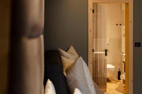莫埃纳Suite del Podesta'的客房设有带枕头的沙发和浴室。