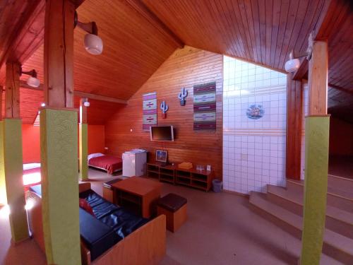 IruUrusel Hostel的一间配有沙发、电视和楼梯的客房