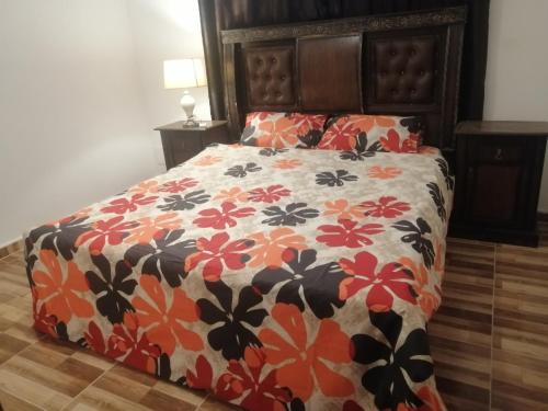 瓦迪穆萨The Stunning View的一张带橙色和黑色花卉棉被的床
