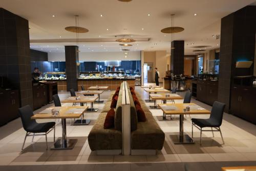 伊斯坦布尔Nova Plaza Prime Hotel的一间带桌椅的餐厅和一间酒吧