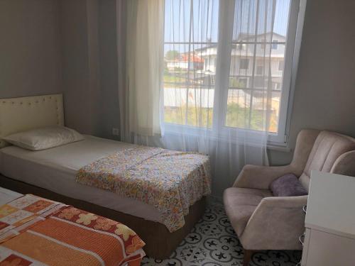 马尔马拉Doğa Evleri的卧室配有床、椅子和窗户。