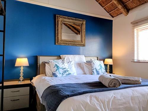 威特班克Sedgefield Lodge的一间卧室设有蓝色的墙壁和一张带枕头的床。
