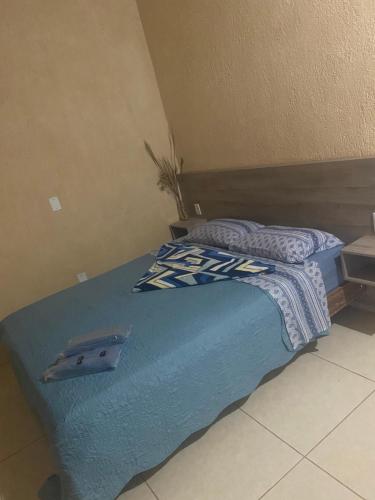 瓦尔任博尼塔Pousada Chales da Canastra的一张带蓝色毯子和枕头的床