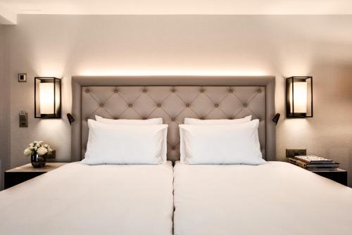 卢塞恩阿斯托里亚酒店的卧室配有一张带两个枕头的大白色床