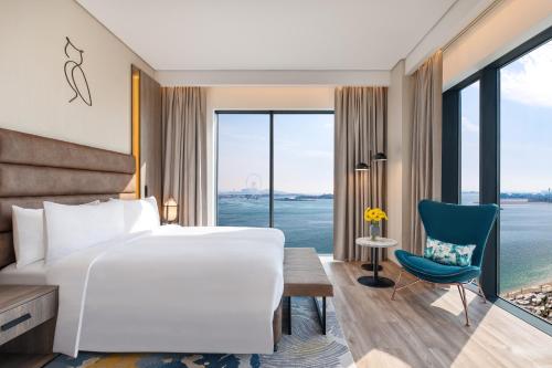 迪拜voco Dubai The Palm, an IHG Hotel的配有一张床、一张书桌和一扇窗户的酒店客房