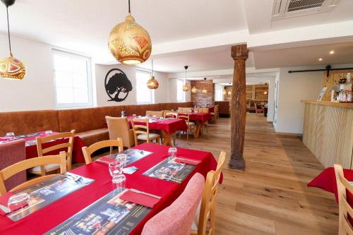 卡佩尔-格拉芬豪森Black Forest Hotel Kappel-Grafenhausen的一间设有红色桌椅的用餐室