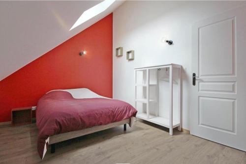 Conches-en-OucheGîte de saint Calais的一间卧室设有一张床和红色的墙壁
