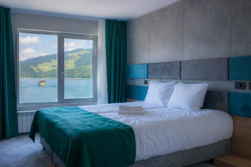 比卡兹Hotel Plutitor Lebăda的一间卧室设有一张大床和大窗户