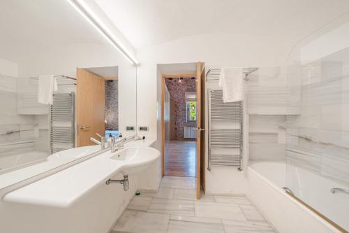埃斯特连克斯Es Port Estellencs的白色的浴室设有浴缸、水槽和浴缸。